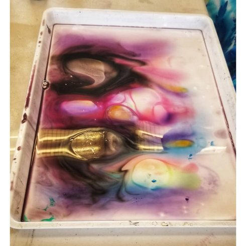 Colors left in a tray after pulling sumi, a dark rainbow