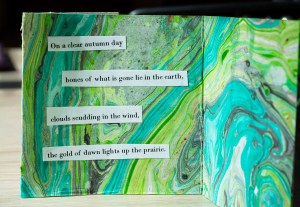 green accordian book, done with suminagashi and collaged poem