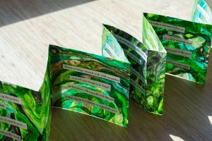 green accordian book, done with suminagashi and collaged poem
